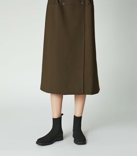 Person wearing a brown midi skirt and black boots.